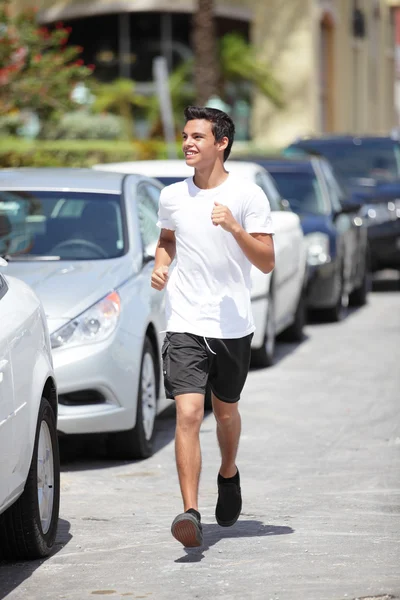 Молодой мужчина бежит по улице — стоковое фото