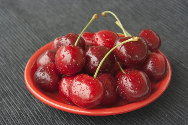 Cherries on a red plate — Stock Photo, Image