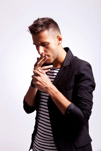 Young fashion guy lighting his cigarette — Stock Photo, Image
