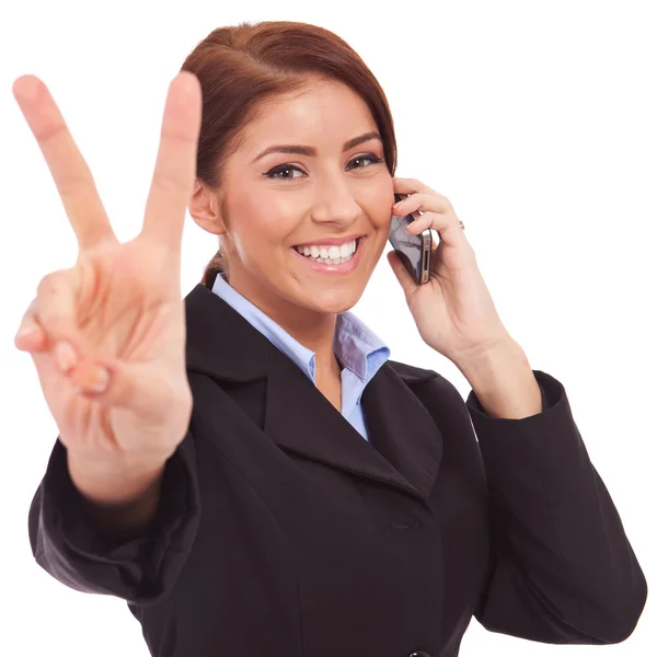 Женщина с телефоном и победным жестом — стоковое фото