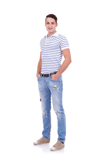 Молодой человек стоит с руками в карманах
