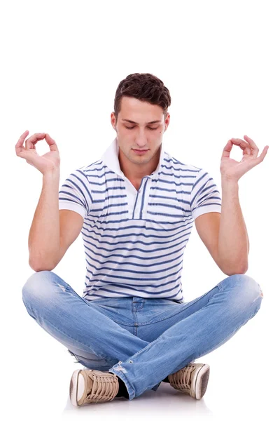 Ung, kjekk mann som mediterer. – stockfoto