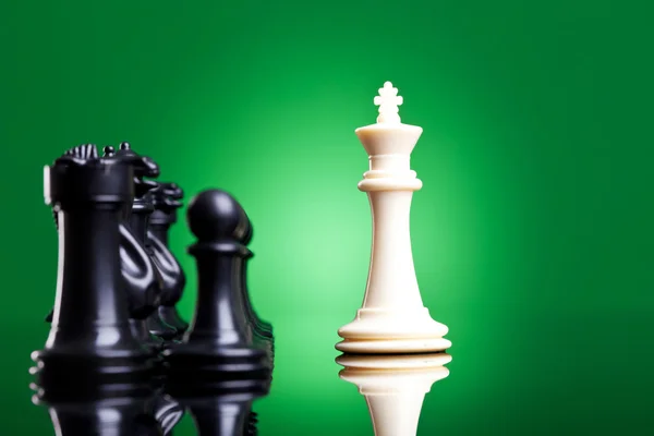 Rey blanco frente a las piezas de ajedrez negro — Foto de Stock