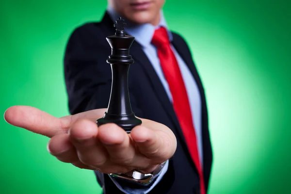 Rey del ajedrez en la palma de un joven hombre de negocios —  Fotos de Stock