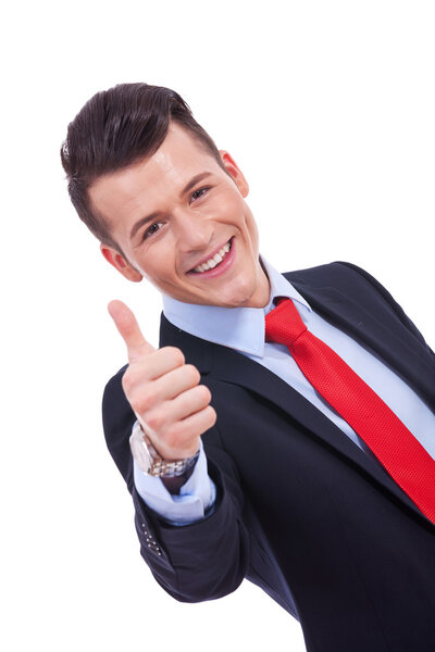 Smiling confident business man holding his thumb up ok sign on white background
