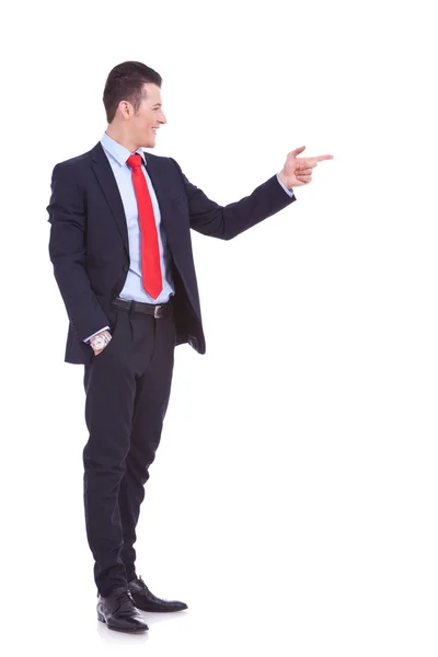 Stilig ung affärsman som pekar på hans sida — Stockfoto
