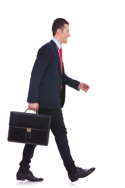 Vista lateral homem de negócios segurando breve caso e andando — Fotografia de Stock