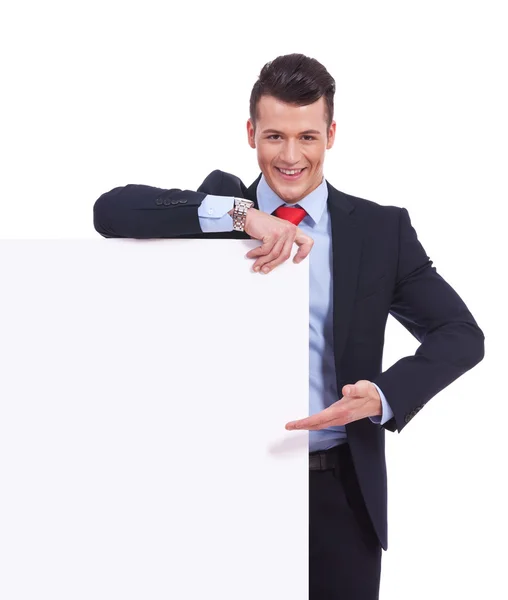 Jovem homem de negócios apresentando um quadro em branco — Fotografia de Stock