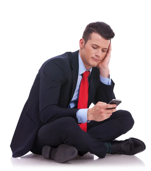 Pensivo jovem empresário está lendo uma mensagem de texto — Fotografia de Stock
