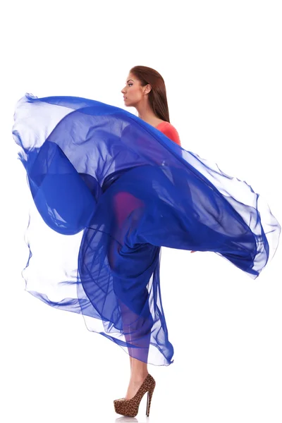 Schöne Frau im blau schwingenden fliegenden Kleid — Stockfoto