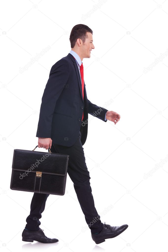 Side view business man holding brief case and walking