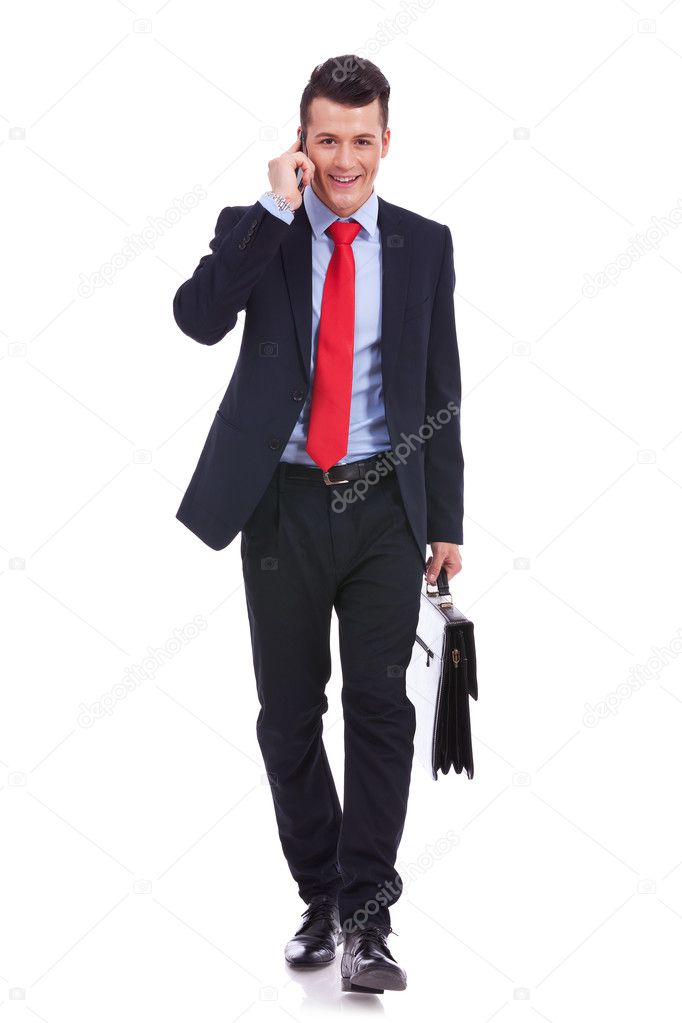 Business man with suitcase walking and talking on phone