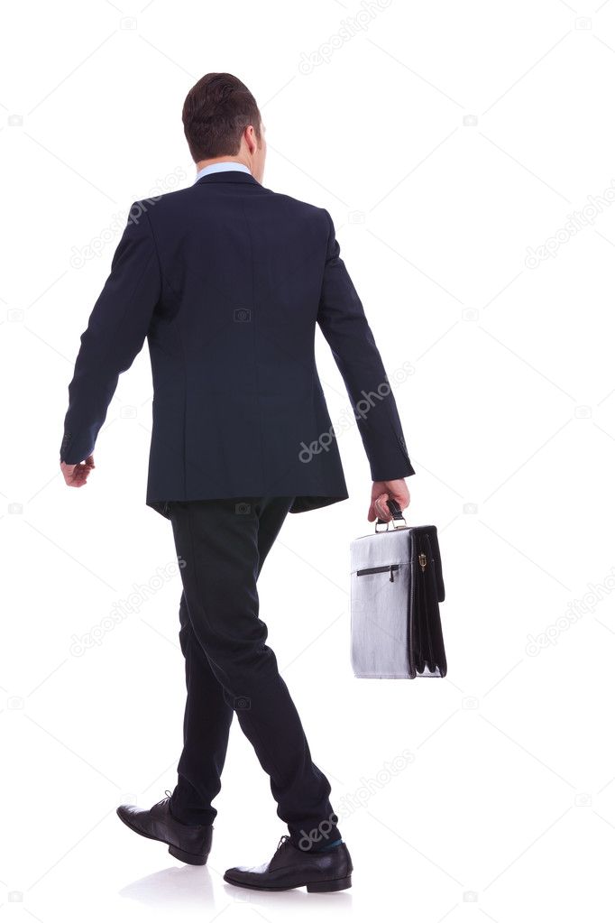 Back of a walking business man holding a briefcase