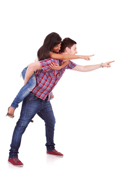 Mladý muž se svou přítelkyní, směřující na něco — Stock fotografie