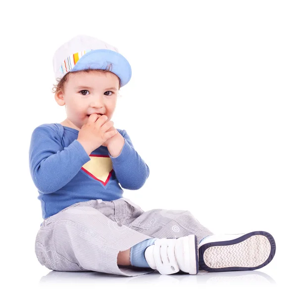 Niño encantador sentado y sosteniendo sus manos en su boca —  Fotos de Stock