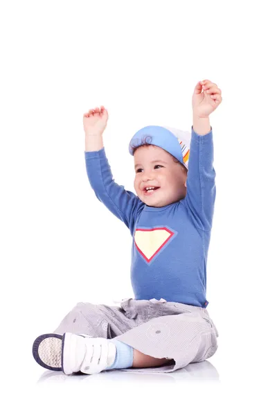 Örömteli kisfiú ül a karját felemelte, és nevetve — Stock Fotó