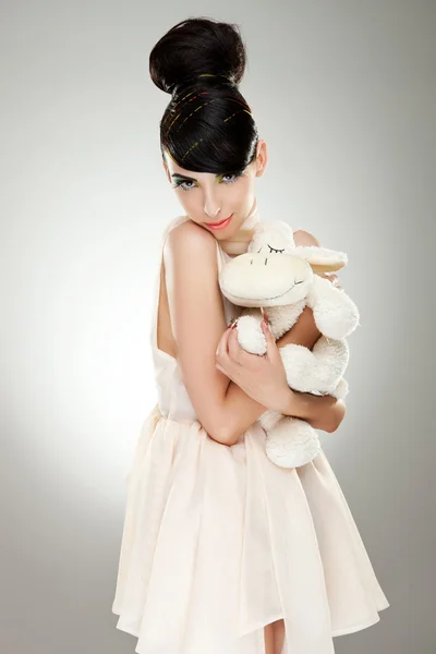 Жінка модель обіймає пухнасту овечу іграшку — стокове фото