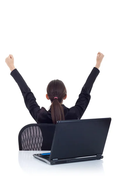 Backview of a young business woman cheering in front of laptop — Stock Photo, Image