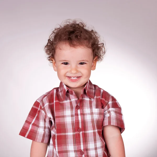 Kleine jongen kijken naar de camera en glimlachen — Stockfoto