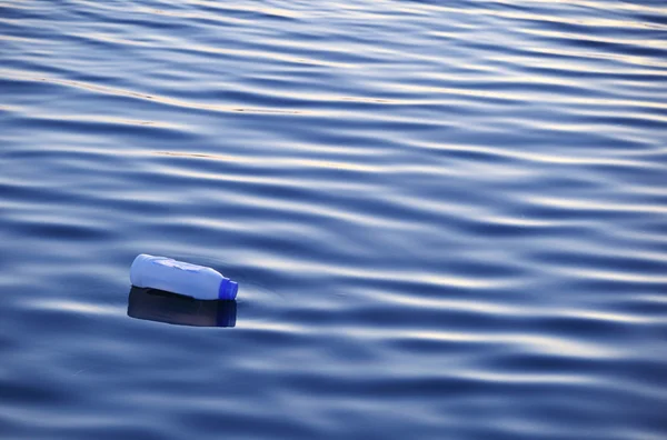 Garrafa de plástico flutuando na superfície da água — Fotografia de Stock