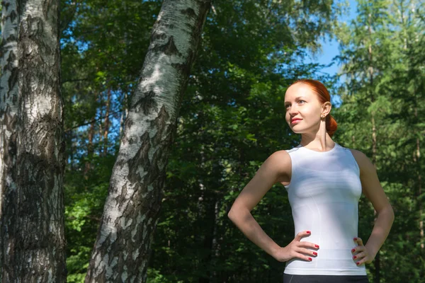Junge rote Frau steht im Wald — Stockfoto