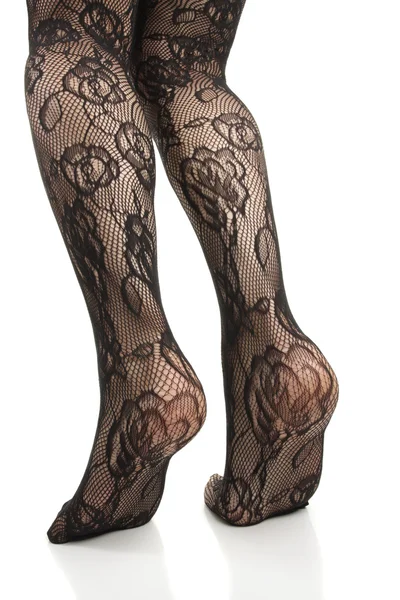 Женские ноги в черных кружевных колготках на белом фоне — стоковое фото
