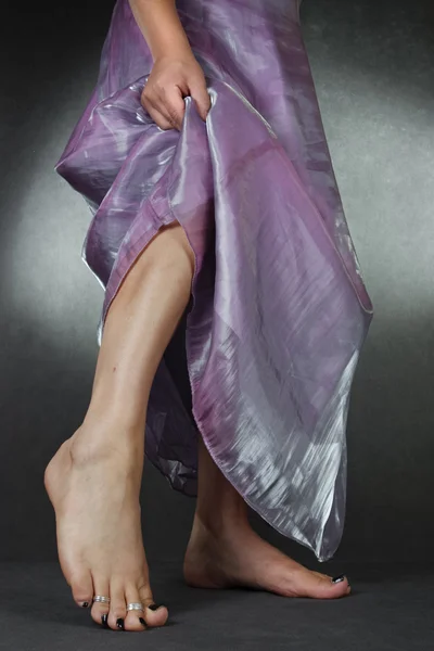 Žena na sobě saténové fialové nevěsta šaty šedé pozadí — Stock fotografie
