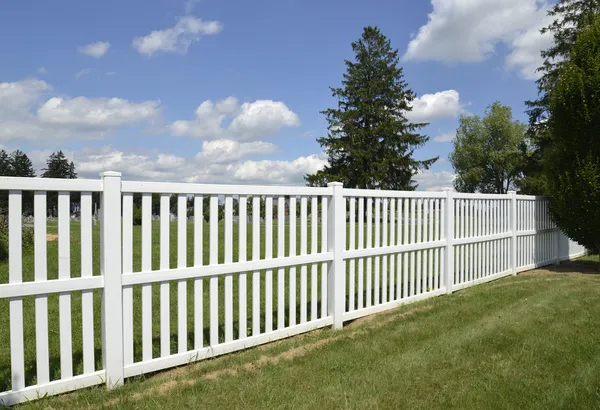 Bílý vinyl plot o zelený trávník — Stock fotografie