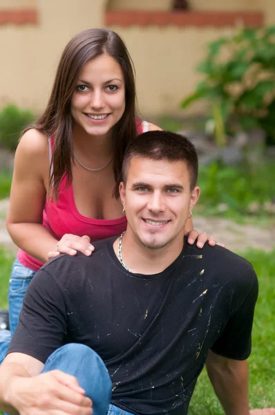 Bela jovem casal feliz se divertindo na grama — Fotografia de Stock