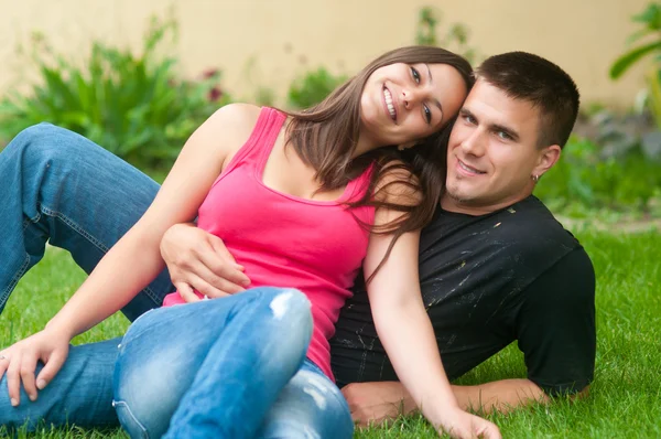 Красивая молодая счастливая пара веселится на траве — стоковое фото