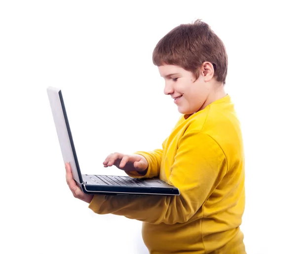 Happy chubby teenage boy working on notebook isolated on white — Stock Photo, Image