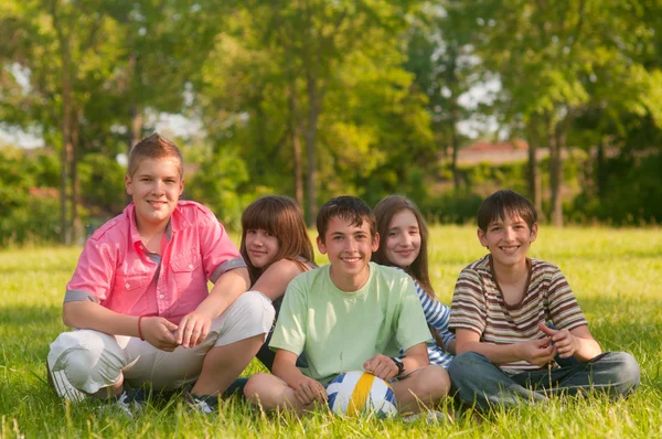 Happy teenage friends spending time together in the park on sunny ...