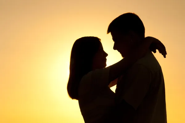 Güneşli bir yaz günü sarılma genç çiftin Silhouettes — Stok fotoğraf