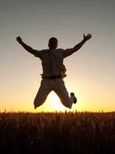 Young man jumping high in the air on sunny summer day — Stock Photo, Image