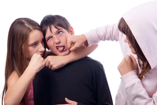 Две девочки-подростки избивают мальчика, изолированного на белом — стоковое фото