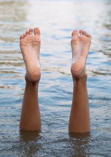Vrouwelijke benen en voeten ondersteboven in het water — Stockfoto