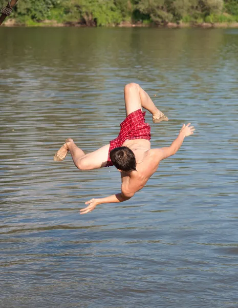 Menino adolescente pulando no rio no dia ensolarado de verão — Fotografia de Stock