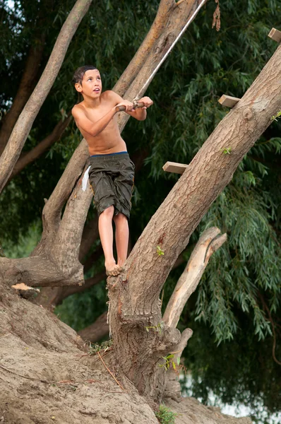 Adolescente saltando al río desde la cuerda que cuelga del árbol —  Fotos de Stock