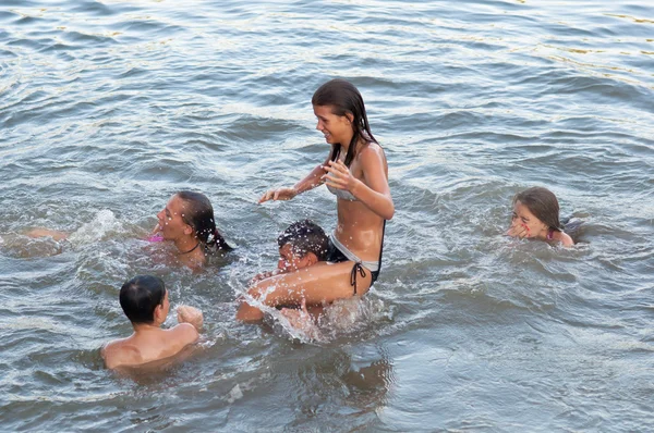 Nastoletni chłopcy i dziewczyny zabawy w wodzie na piękny letni dzień. — Zdjęcie stockowe