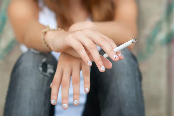 Las manos adolescentes sosteniendo el cigarrillo — Foto de Stock