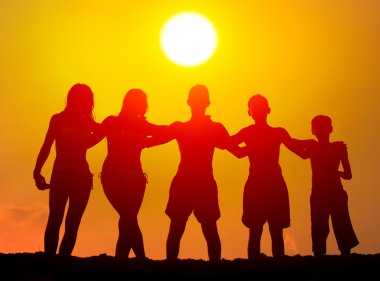 çocuklar ve kızlar sahilde güneşli yaz gününde sarılma Silhouettes