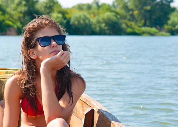 Linda chica adolescente tomando el sol en el barco en el soleado día de verano — Foto de Stock