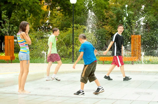 stock image Teenage boys and girls having fun in the towns water fountain on hot summer day