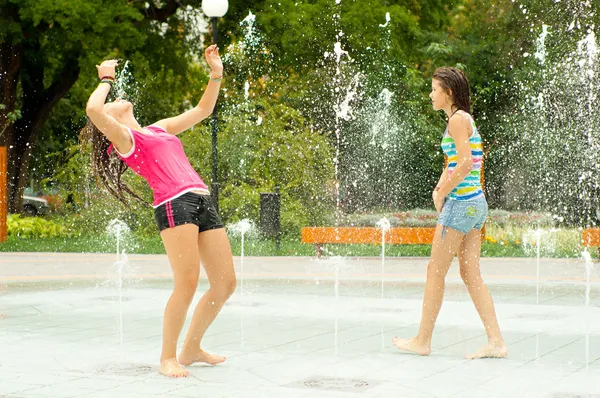 Девочки-подростки веселятся в городском фонтане в жаркий летний день — стоковое фото