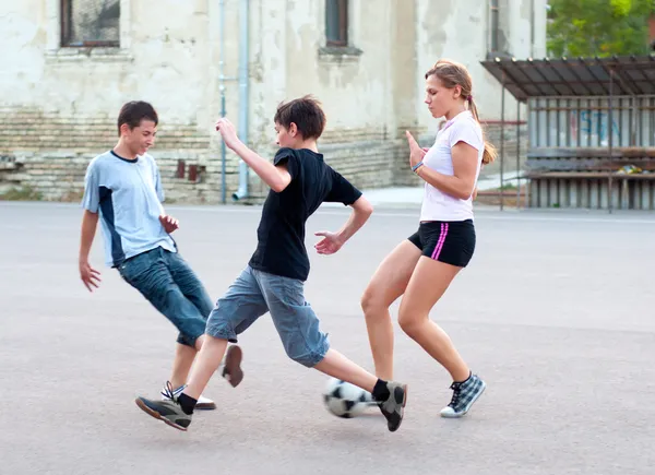 Teenage boys and girls playing soccer on the playground — Stock Photo, Image