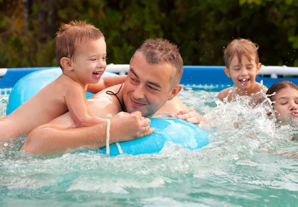Père et ses enfants s'amusent dans la piscine lors d'une belle journée d'été — Photo