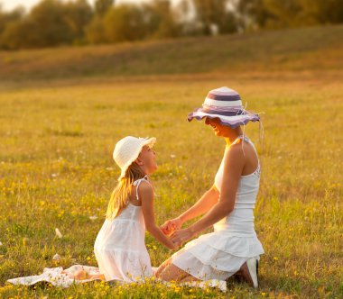 Anne ve kızı eğleniyor çayır on güneşli yaz gününde