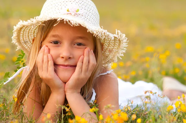Schattig klein meisje liggend op de weide op zonnige zomerdag — Stockfoto