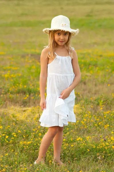 Schattig klein meisje permanent op de weide op zonnige zomerdag — Stockfoto