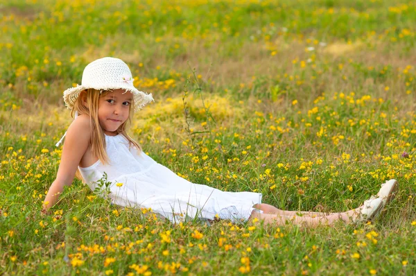 Schattig klein meisje liggend op de weide op zonnige zomerdag — Stockfoto